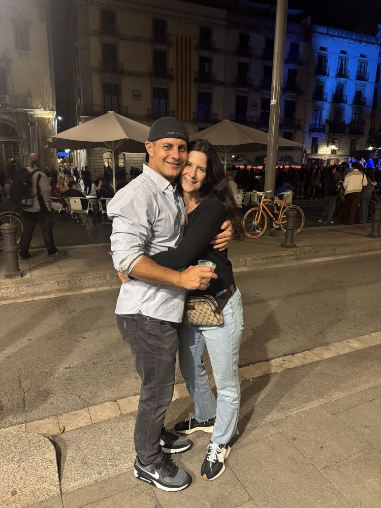 Rob and Nadine hugging in a Barcelona square at night